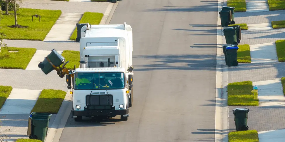 Waste management collection vehicle in residential neighborhood