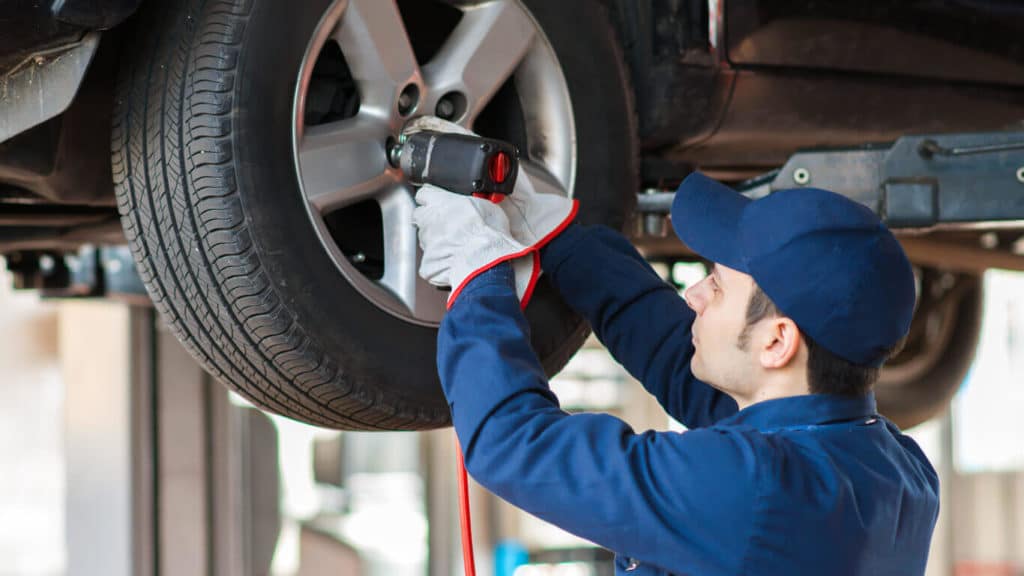 Man torquing the lugs on a car, EV fleet management, Electric Vehicle Fleet management, and EV charging