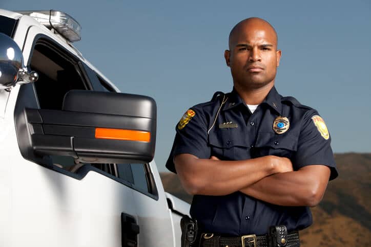 Police officer looks into camera with arms crossed