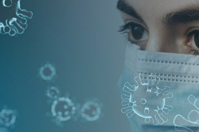 a woman wears a face mask with the cornavirus particles floating around the image