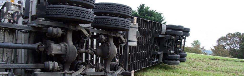 A truck lays on its side after a crash in a field