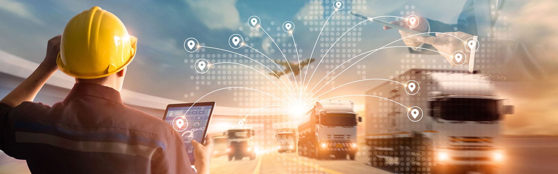 a man looks at a fleet of trucks holding a digital pad