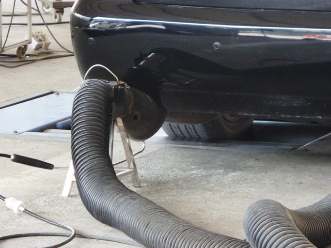a government fleet vehicle gets a smog emissions test in a garage - Government Fleet Management