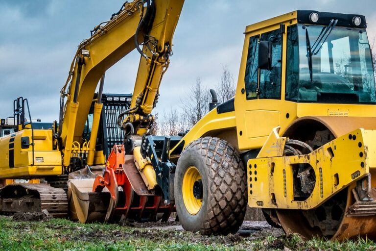 a row of yellow iron construction equipment sits lined up