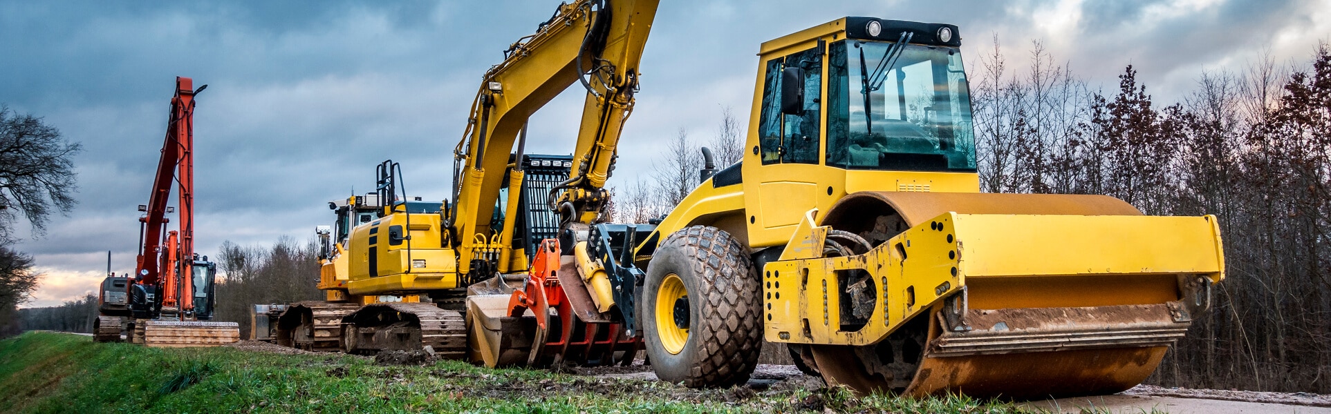 a row of yellow iron construction equipment sits lined up