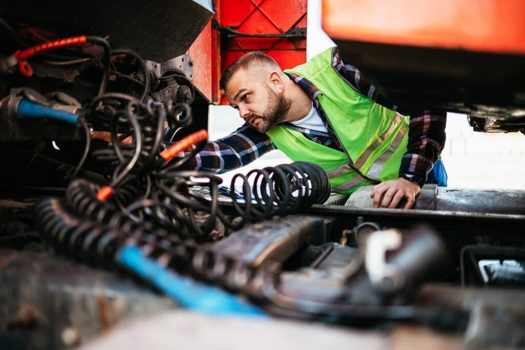 Technician performing maintenance on a company truck to prevent an accident or other potential problems