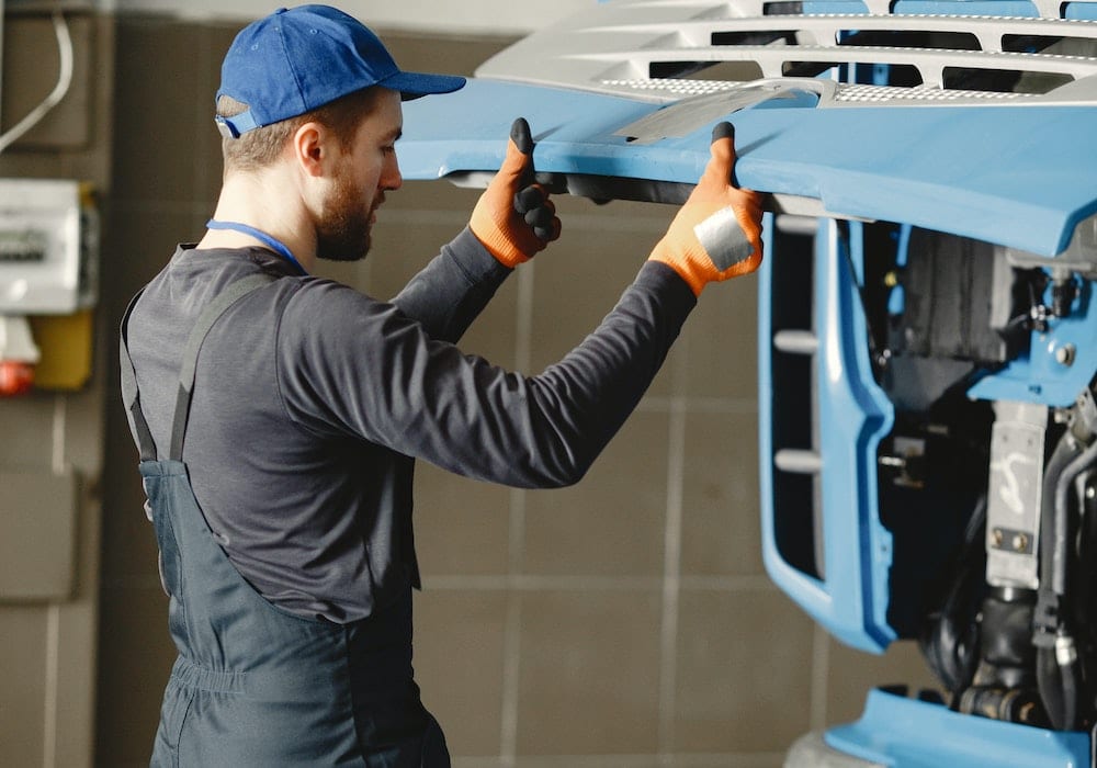 man inspecting an engine bay