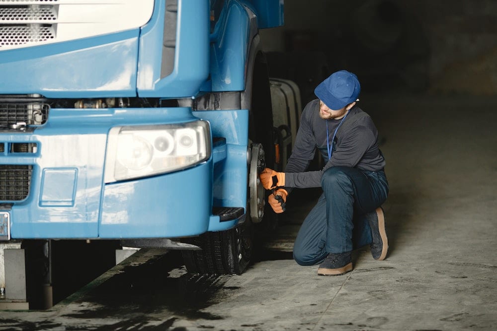 man tightening wheel lugs - fleet maintenance