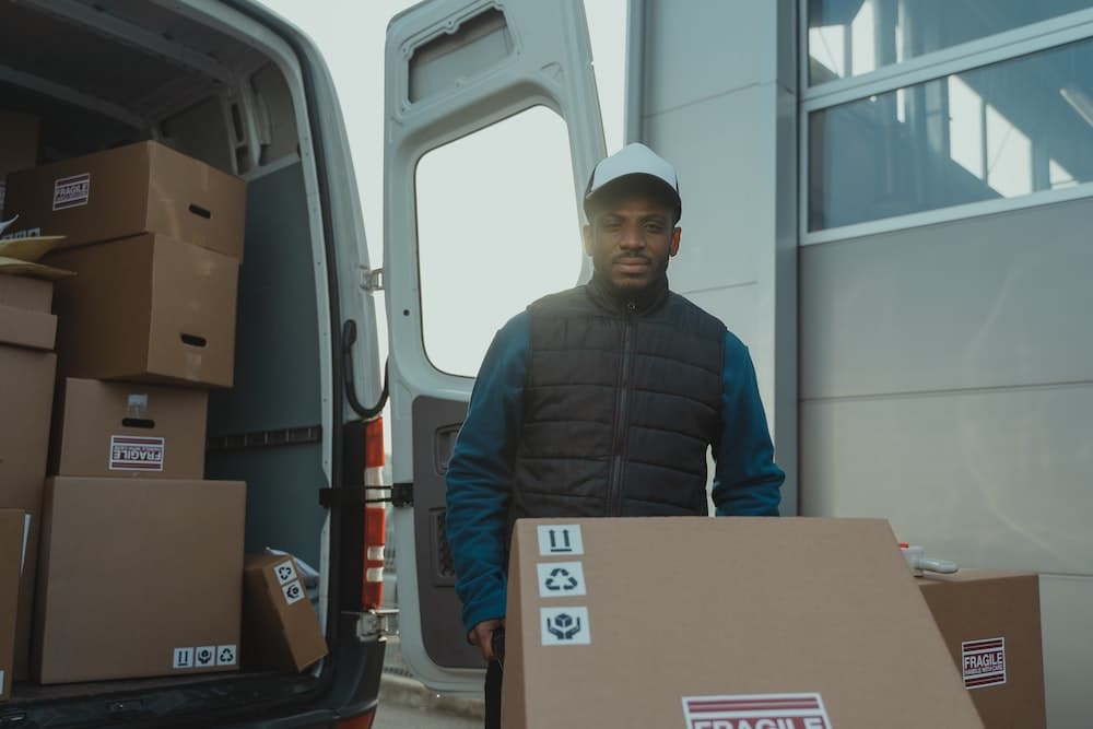 Man unloading cargo from internal combustion engine van