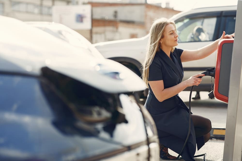 Woman at an electric vehicle charging station