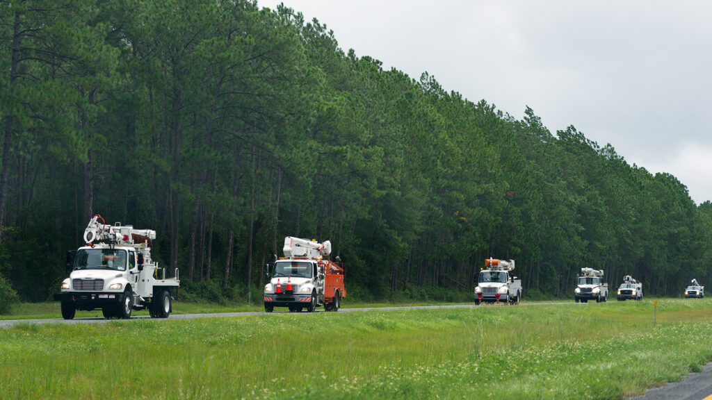 Utility trucks coordinating to assist disaster recovery efforts through Mutual Assistance Agreements.