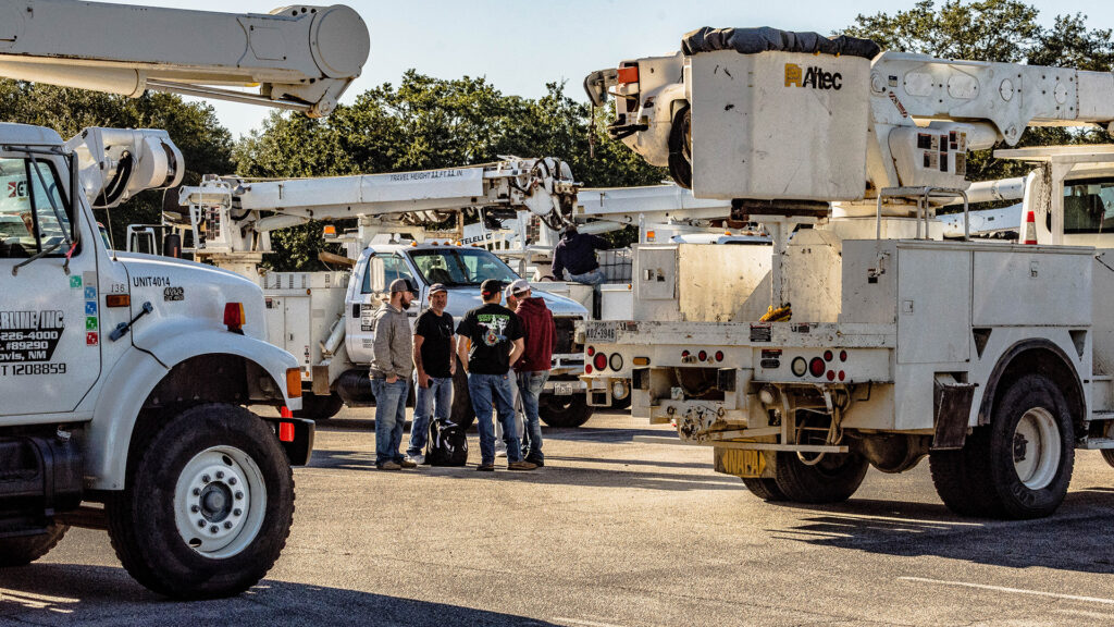 Utility workers regroup after performing disaster recovery assistance to asses their performance.