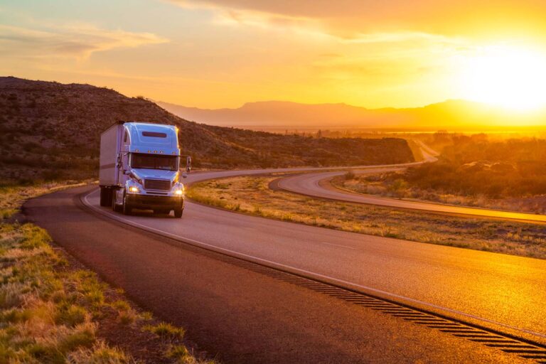 Semi-truck driving down a desert highway.