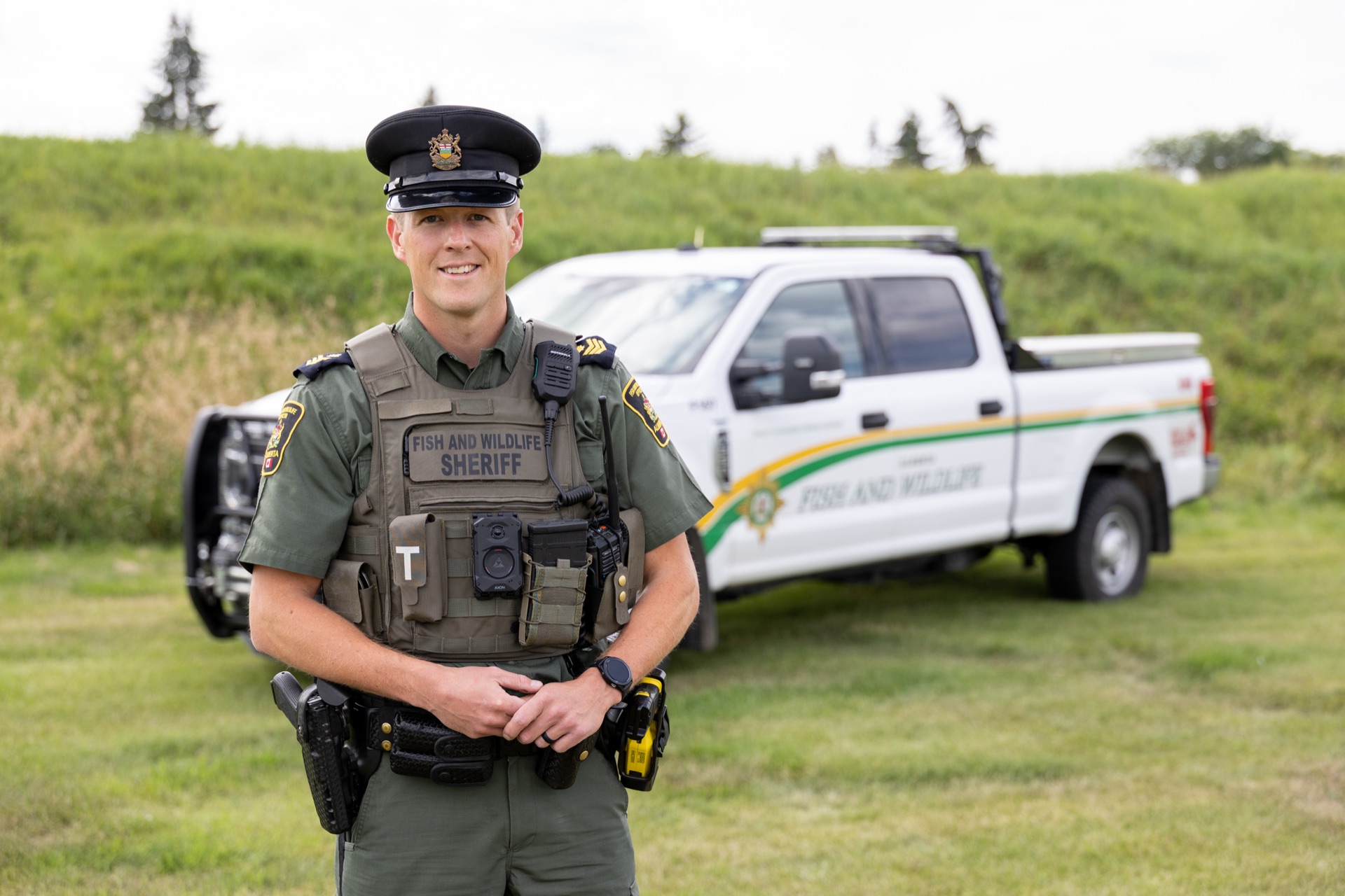 Alguacil de Vida Silvestre y Pesca de Alberta frente a un camión de cumplimiento de la ley