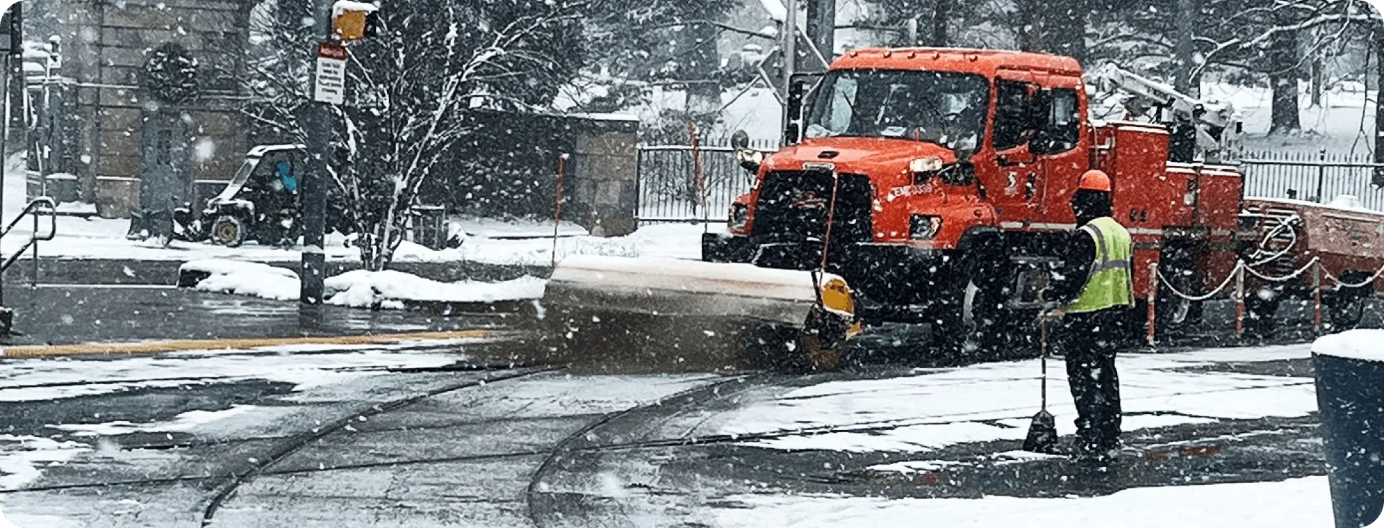 Trabajador de SEPTA y quitanieves limpiando la nieve de una estación de tránsito.