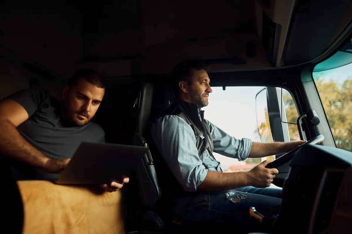 Driver at the wheel with a second crew member in the cab