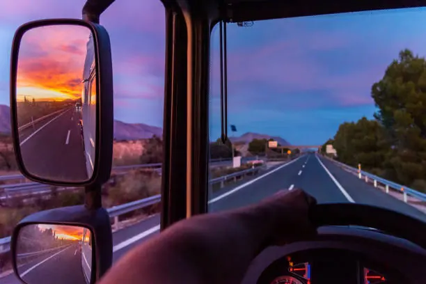 Driver's seat view down the highway at dusk