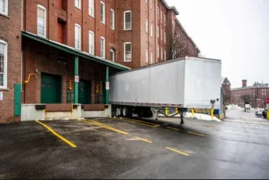Dropped trailer standing at a loading dock with no tractor