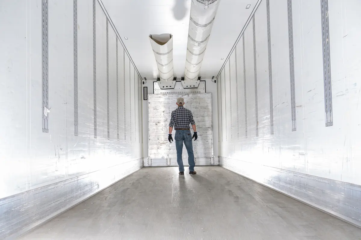 Worker inside an empty trailer at the loading dock