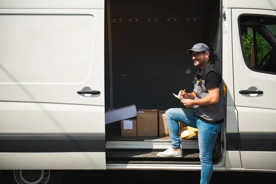 Courier at the door of a delivery van
