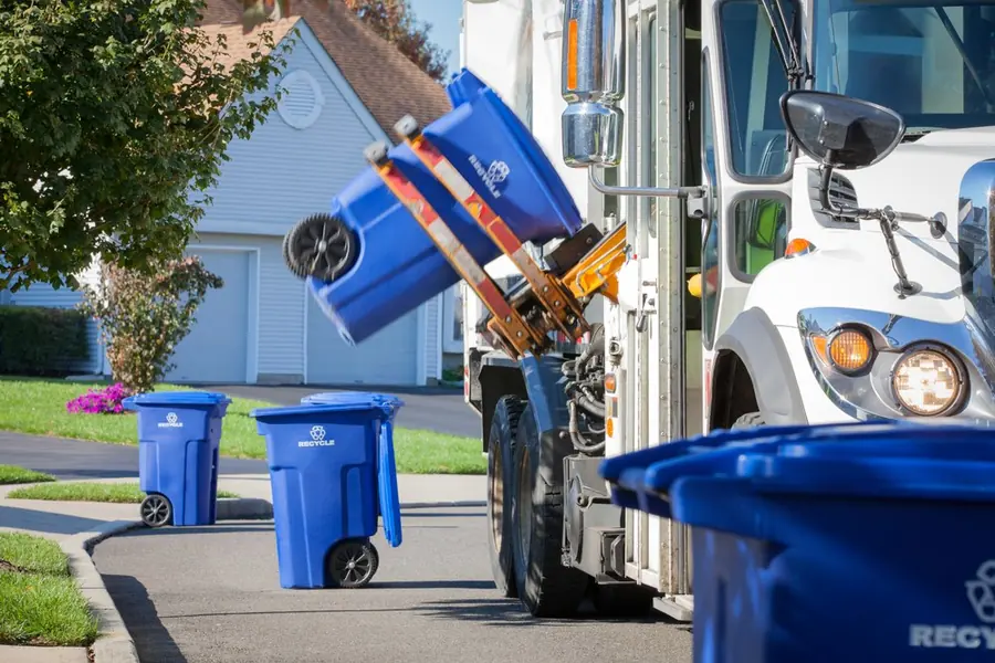 Refuse truck lifting a curbside recycling cart