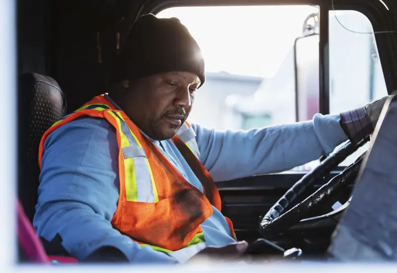 Driver in the cab reviewing a safety event on his phone